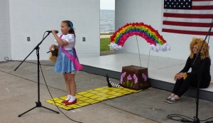 Little Miss Superior contestant Aubrie Dove sings "Over the Rainbow" while L'Anse High School cheerleader Jessica Wickstrom looks on.