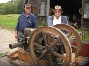 Oscar Heikkinen and George Kauppila stand with 100 year old hit and miss engine they will be demonstrating at the Hanka Homestead Family Heritage Day on Saturday, August 20.