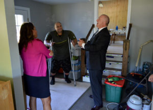 (L-R) Lisa Lehman (MSHDA Key to Own program), Tom Rossi and Kevin Elsenheimer talk in the entryway of Rossi's new home.